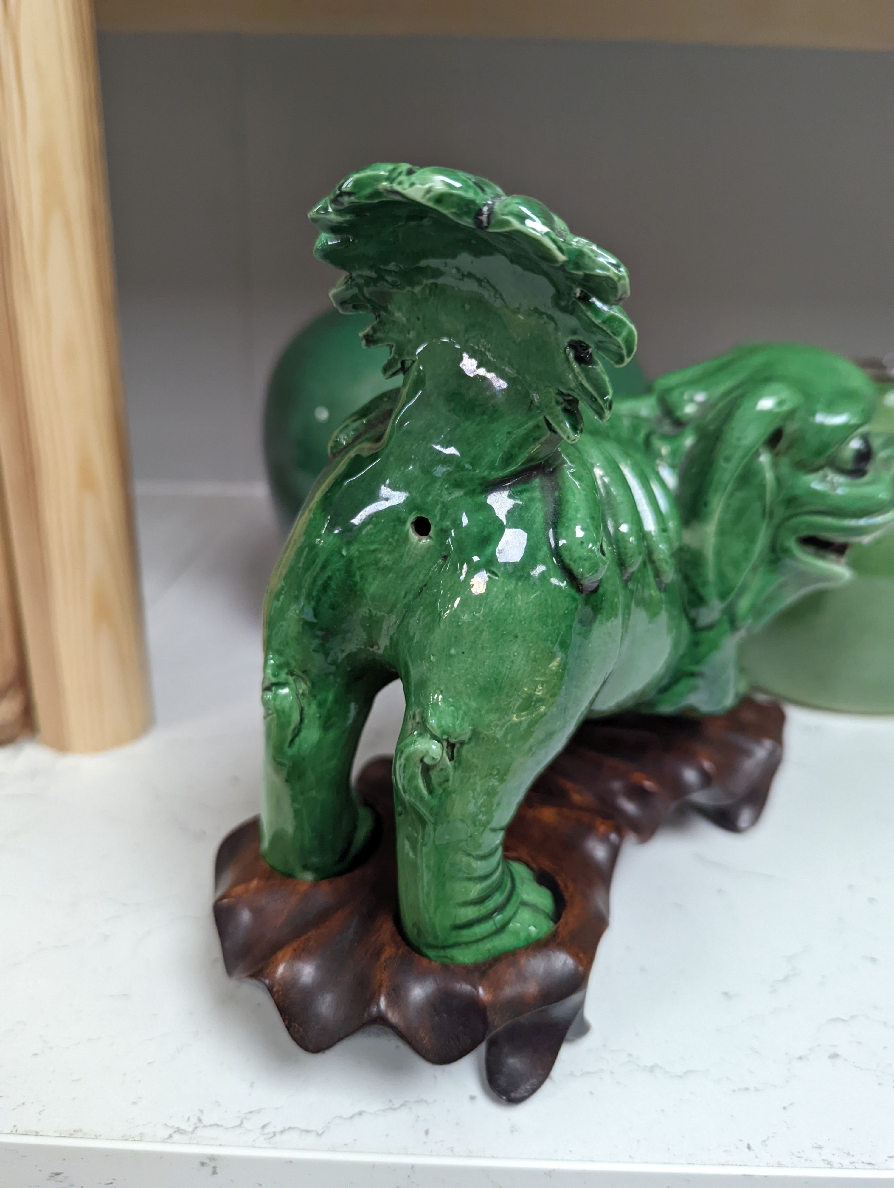 A 19th century Chinese green glazed model of a lion-dog, and two green crackle glaze jars, tallest 16cm